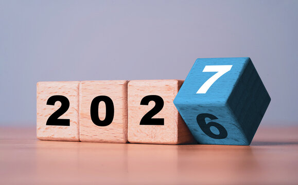 Wooden blocks changing from 2026 to 2027 symbolize new year transition for future business planning goals, fresh change start, progress strategy growth and preparation for upcoming opportunities.