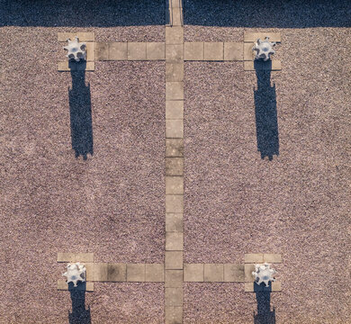 Aerial view of industrial electrical equipment on a gravel rooftop, creating a symmetrical geometric pattern with long shadows in Saulce-sur-Rhone, Auvergne-Rhone-Alpes, France.