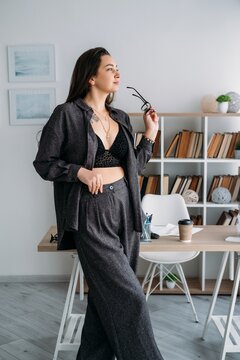 Female worker. Office routine. Stylish relaxed entrepreneur business professional at workplace with coffee document at desk indoor.