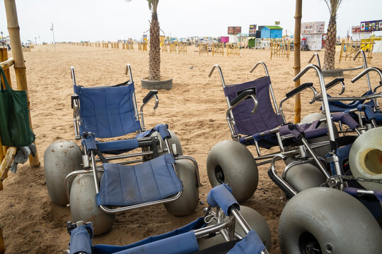 Beach wheelchairs with wide wheels placed on the sand for accessibility