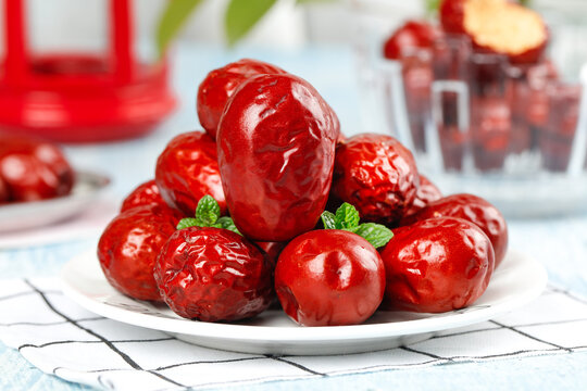 Ruoqiang Red Jujube Dates from Xinjiang China - Traditional Dried Fruit Superfood on White Plate with Fresh Mint