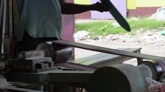 Artisan smoothing mirror glass edges with belt sander