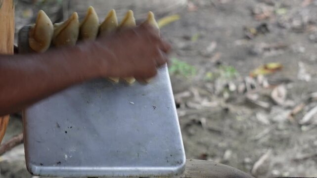 Person gently lowering potato samosas into hot oil
