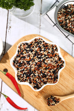 Organic Mixed Rice Varieties in Star Bowl - Brown Black Red Wild Rice Grains on Wooden Board