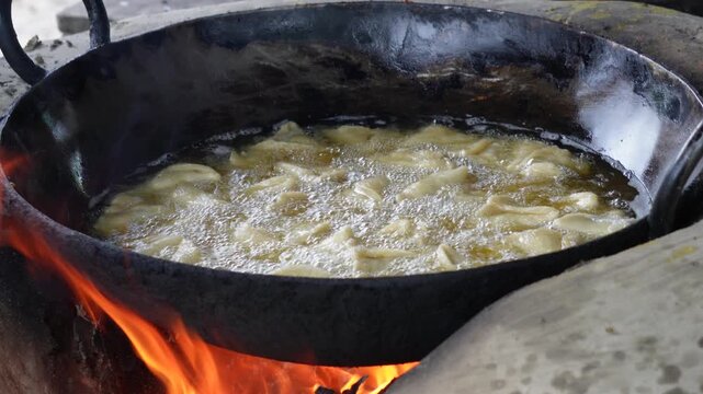Samosa deep frying over open fire