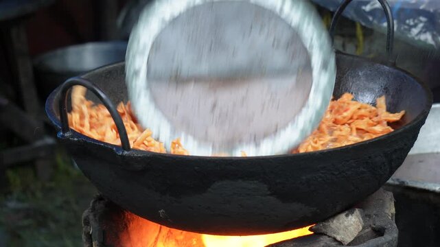 Namkeen sizzling in hot oil over wood fire