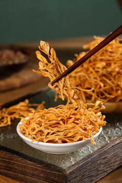Traditional Chinese Medicine Dried Cordyceps and Chrysanthemum Flowers with Wooden Chopsticks in Bowl