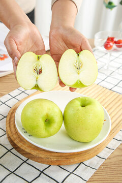 Fresh Green Apples Being Cut in Half Showing Interior on Kitchen Counter