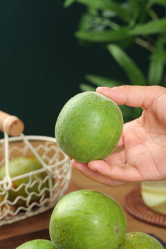 Luo Han Guo Monk Fruit in Hand with Traditional Tea Infusion Setup for Natural Health Benefits