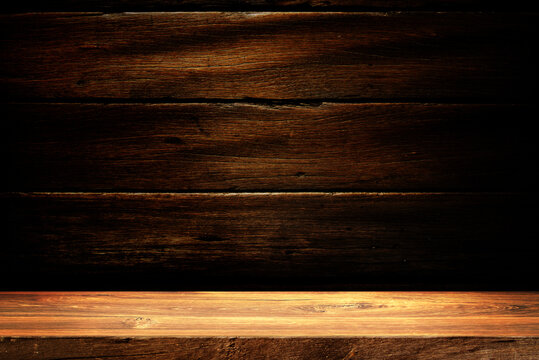 Wooden table in dark room background concept for advertising.