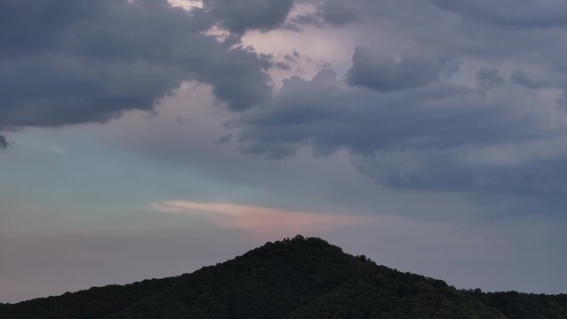 silhouette of mountain peak against cloudy sky at dusk
