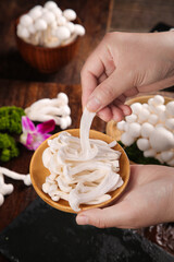 Fresh White Edible Mushrooms from Yunnan in Wooden Bowl - Hand Picking Wild Fungi for Healthy Cooking © NguyenVan