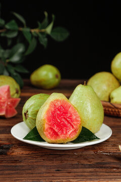 Fresh Ripe Guavas with Deep Red Heart-Shaped Flesh on Rustic Wooden Table