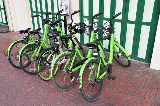row of bicycles sharing parked belong vintage building on sidewalk, bike rental service used by scan QR code, eco friendly travel, city sustainability transport, BANGKOK, THAILAND - August 11, 2026