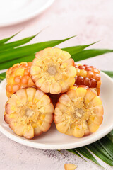 Yunnan Flowered Glutinous Jade Corn Cobs on White Plate with Green Leaves © CanVan