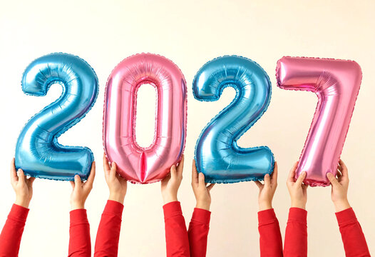 Happy people holding colorful foil balloons spelling out the new year celebration countdown