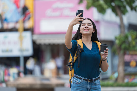 Young asian woman traveler taking selfie in city