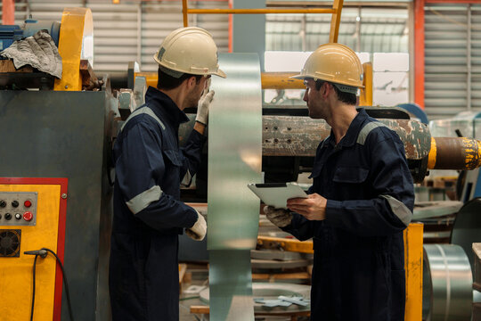 Engineers and staff are inspecting the assembly line system in a metal sheet and metal roofing manufacturing plant.
