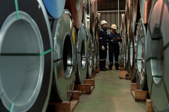 Engineers and staff are inspecting the assembly line system in a metal sheet and metal roofing manufacturing plant.