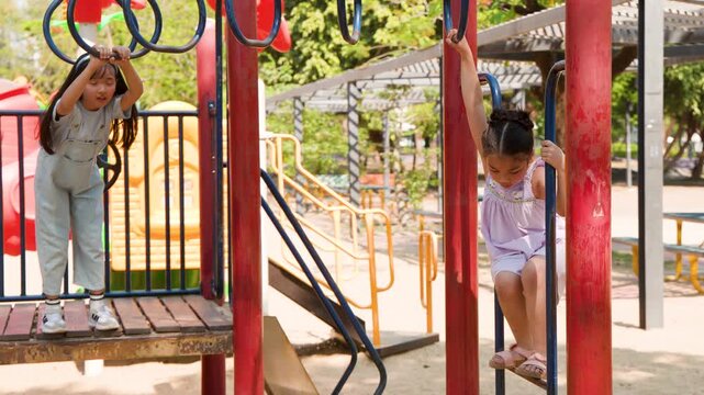 Two Young Girls Playing on Monkey Bars at Lumpini Park