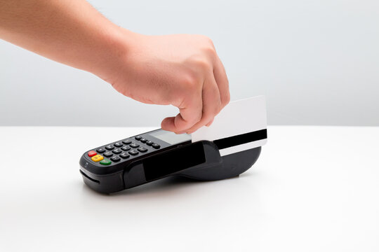 Hand swiping payment card on card reader terminal for cashless transaction