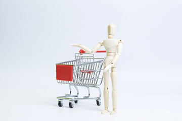 Wooden mannequin with shopping cart isolated on white background © PhamHong