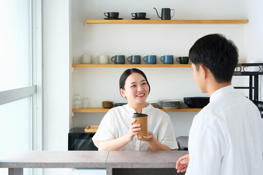 Young Japanese Woman Laughing and Talking with Cafe Staff at Counter