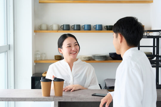 Young Japanese Woman Laughing and Talking with Cafe Staff at Counter