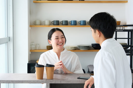 Young Japanese Woman Laughing and Talking with Cafe Staff at Counter