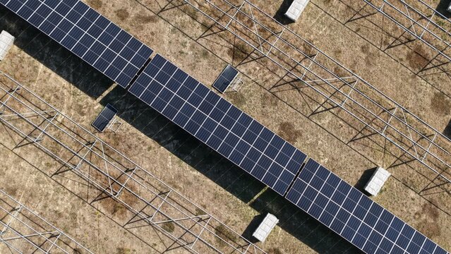 Aerial view of the Common Park Solar Farm under construction, featuring rows of installed solar panels alongside metal mounting structures on dry, open land in Sheffield, England, United Kingdom.