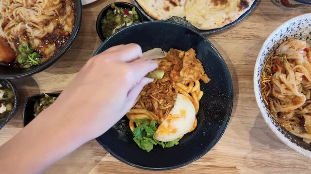 Overhead View of Person Squeezing Lime onto Burmese Nan Gyi Tote