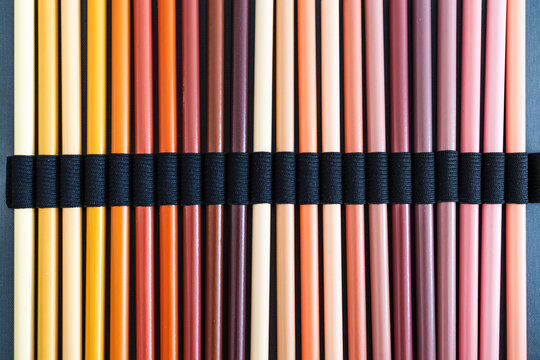 close-up of ochre brown and skin tones pencils neatly lined up in pencil case, concept of creativity, drawing, education and art supplies