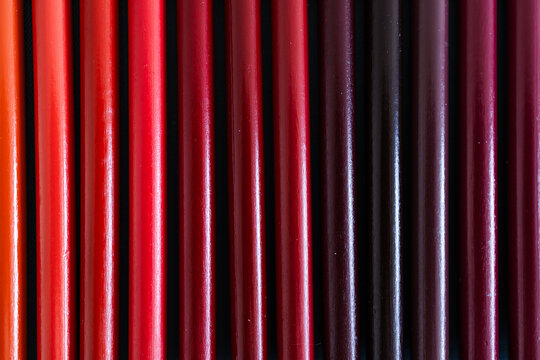 close-up of yellow orange and red colored pencils neatly lined up in pencil case, concept of creativity, drawing, education and art supplies