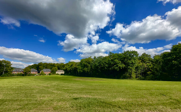 Serene rural panorama, Quiet countryside with cloudy skies and cottages