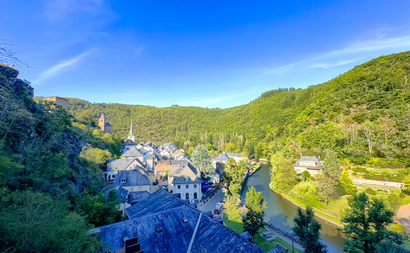 Esch-sur-Sure, Wiltz, Grand-Duche de Luxembourg, September 07, 2025, Hillside panorama of historic village with river curve and clustered rooftops, lush forests on surrounding ridges, sweeping