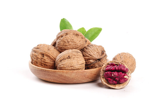 Xinjiang Walnuts with Purple Coated Kernels in Wooden Bowl on White Background