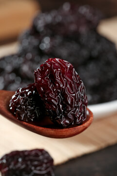 Dried Jujube Dates from Xinjiang China - Big Purple Black Crystal Fruit in Wooden Spoon Close-up