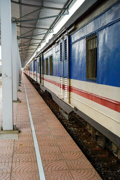 A colorful train parked at a modern platform, ready for passengers.