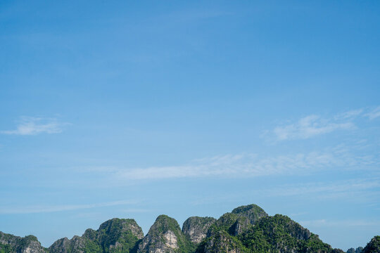 Serene landscape of lush green mountains under a clear blue sky.