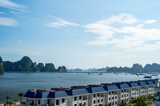 Scenic waterfront view with boats and rocky cliffs under a clear blue sky.
