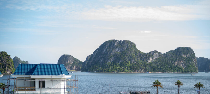 Scenic coastal view with mountains and a partially constructed building.