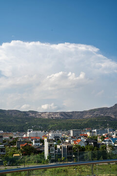A sunny day over a vibrant city landscape with fluffy clouds in the background.
