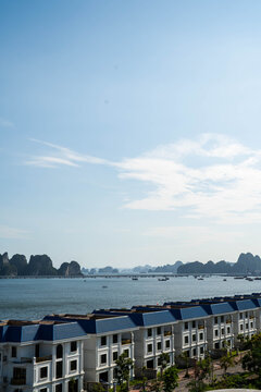 Stunning seaside view with calm waters and distant limestone islands under a clear sky.