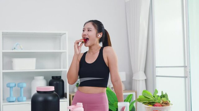 Fit Asian woman presenting organic food recipes for fitness goals on vlog channel. Sporty female content creator recording health and wellness tips with mobile phone camera.