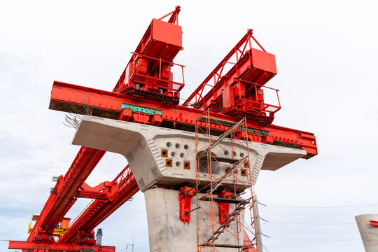 Large launching gantry and precast concrete pier at a bridge construction site, showcasing civil engineering, structural engineering and modern infrastructure development.