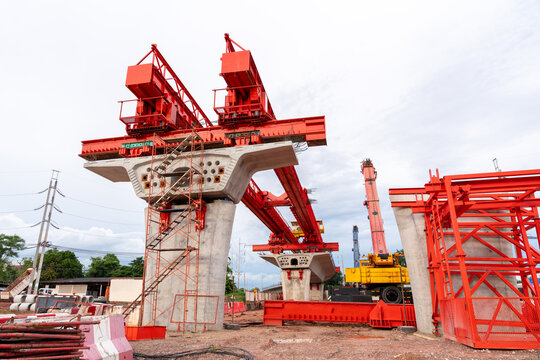 Large launching gantry and concrete piers at an elevated railway construction site, showcasing civil engineering, bridge construction and modern infrastructure development.
