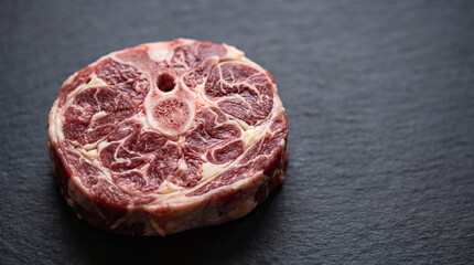 Obraz premium Raw beef shank cross cut on dark slate board