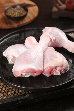 Fresh Raw Chicken Legs and Thighs on Black Plate Ready for Cooking
