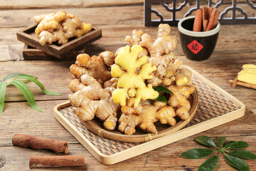 Fototapeta premium Fresh Ginger Root Guangxi Yellow Slices with Cinnamon Sticks on Rustic Wooden Table Asian Cooking Ingredients