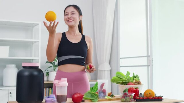 Fit Asian woman presenting organic food recipes for fitness goals on vlog channel. Sporty female content creator recording health and wellness tips with mobile phone camera.